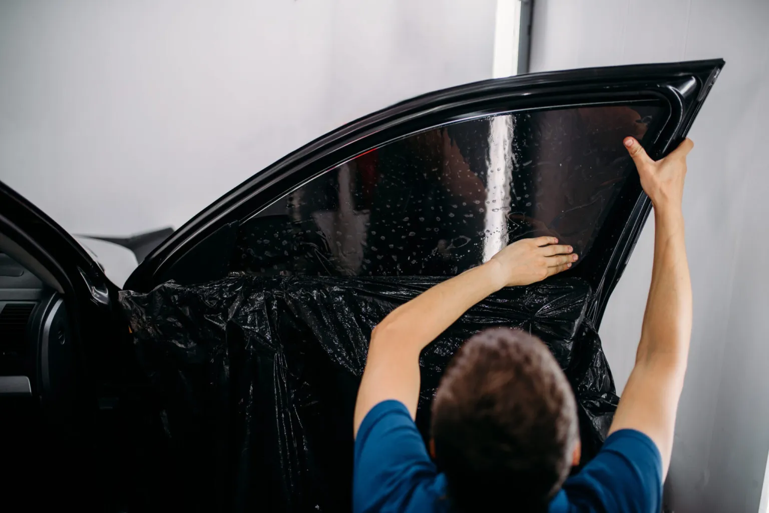 Close-up of a car side window with applied tint—visual aid for “how much tint do I need for my car,” showing opacity and sun-blocking effect. If you’ve got more images or want to add context like climate impact or tint tool usage, I’m totally game to help enhance them!